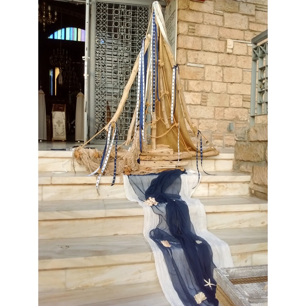 Wedding Boat - Summer decoration with wooden boats and ribbons in various shades of blue, shells, starfish and lanterns on white and blue fabrics.